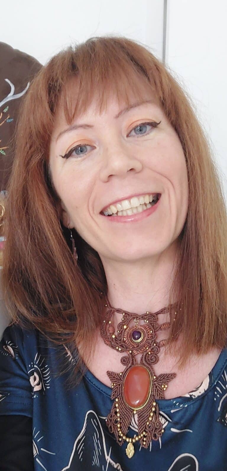 Fanny Boyer, souriante, porte un collier en micro-macramé de sa création