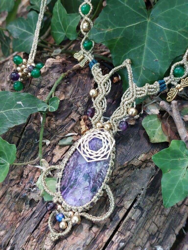 Collier en micro-macramé, fils colorés et pierre naturelle posés sur du lierre